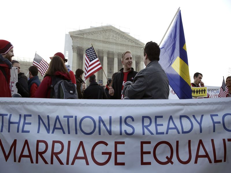 Protesters stand next to a banner outside of the U.S. Supreme Court in Washington