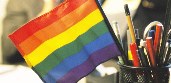 Rainbow flag in pencil holder on office desk